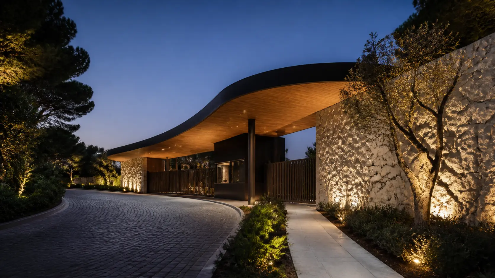 Acceso principal iluminado de una comunidad residencial de Madrid al anochecer